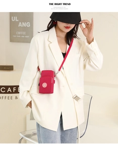 Red nylon crossbody phone bag shown with model in a modern cafe setting