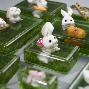 Macro shot of miniature rabbit resin art within translucent green rectangular molds