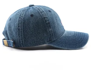 Side view of washed dark blue denim baseball cap featuring vintage brass buckle