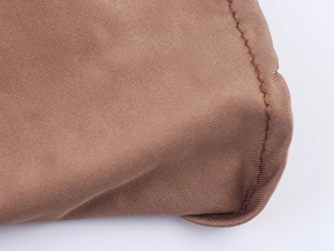 Detailed macro view of brown fabric texture and high-quality stitching on a halter top
