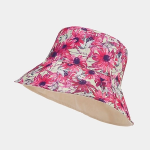 Detailed view of reversible sun hat with red floral patterns and beige lining