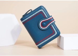Detailed view of blue short wallet with lychee leather texture and floral embroidery