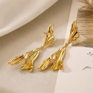 Detailed close-up of 18K gold irregular abstract lava flow earrings with high-shine finish