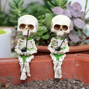 Detailed macro view of two resin fishing skeleton figurines with green moss accents