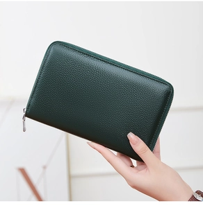 Detail of hand-held dark green textured leather RFID wallet with long zipper closure