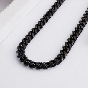 Detail of a sleek black titanium steel Cuban chain necklace with smooth curve placement