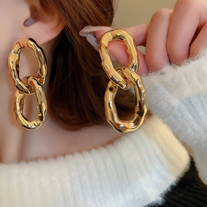 Boucles d'oreilles dorées irrégulières au fini texturé portées par un mannequin