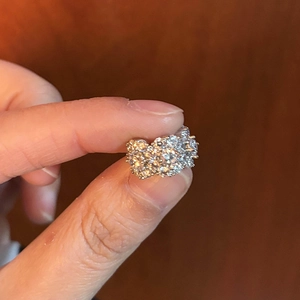 Macro detail of a sparkling zircon flower ring cluster in a silver-toned finish