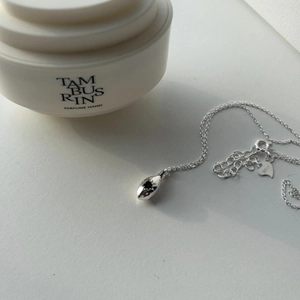 Minimalist 925 sterling silver necklace featuring a black star droplet pendant on white surface