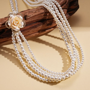 Dettaglio di collana di perle a quattro strati con chiusura a ciondolo a rosa con cristalli