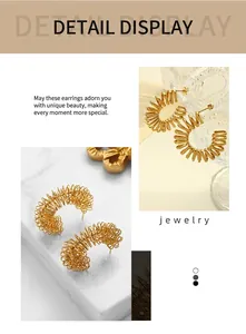 Détail de boucles d'oreilles créoles en acier titane doré avec design spirale unique