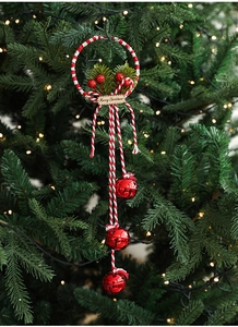 Detail of Christmas wreath ornament with red bells, pine needles and Merry Christmas tag