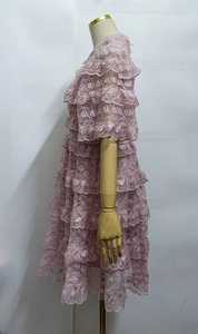 Detailed view of pink layered lace dress featuring ruffles and exquisite jacquard texture