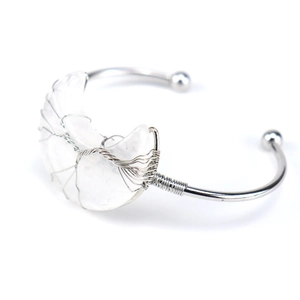 Close-up of handmade silver wire-wrapped moon bangle with translucent natural crystal