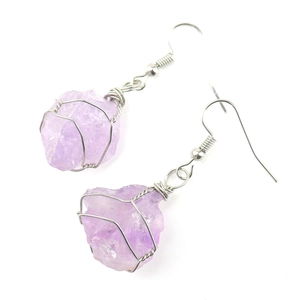 Detail of handmade silver wire wrapped natural raw purple amethyst stone earrings