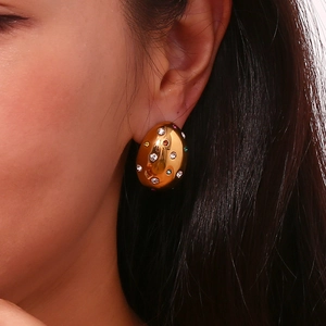 Close-up of model wearing oval 18K gold plated earrings with colorful zircon stones