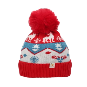 Close-up of Christmas knit hat with elk and snowflake patterns and red plush pom-pom