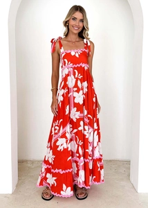 Detail of red floral maxi dress featuring elegant shoulder straps and wave trim