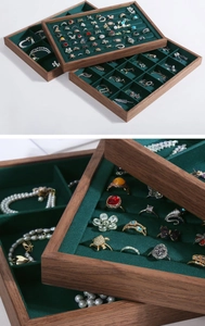 Detail of walnut wood jewelry tray with green velvet lining for rings and necklaces
