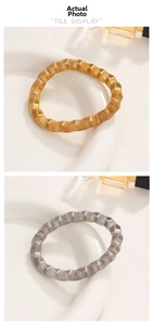 Detailed view of gold and silver twisted bangles with fine spiral texture on ceramic