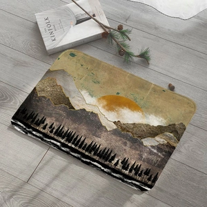 Absorbent flannel mountain print door mat shown on grey wood floor with pine branch decor