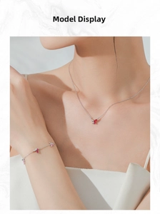 Détail de parure pendentif papillon rose et rouge sertie de zircons sur chaîne argent