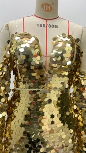 Close-up of sparkling gold sequin evening dress with deep V-neck and thin straps