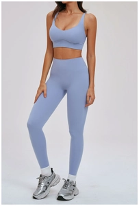 Model draagt een lichtblauwe geborstelde yoga sportbeha en legging met hoge taille