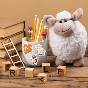 Close-up of cute cartoon squirrel and sheep stickers on a white mug in a warm scene