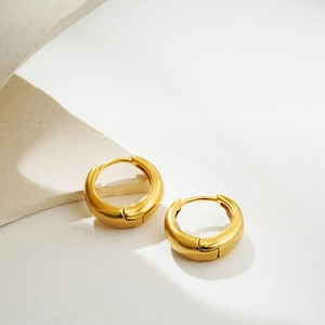 Close-up of chunky 18K gold plated hoop earrings with high-polished mirror finish