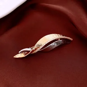 Elegant twisted hair clip with two-tone metal finish and zircon stones on velvet background