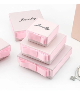Macro view of assorted pink jewelry gift boxes featuring elegant black ribbon bows