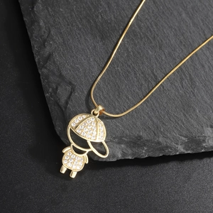 Detail of gold plated boy pendant with sparkling cubic zirconia on dark stone background