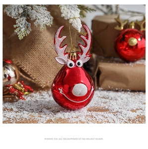 Close-up of a glossy red reindeer ornament hanging in a cozy winter holiday scene
