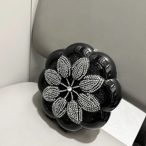 Detail of black flower evening bag featuring white crystals and luxury box design