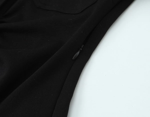 Détail de la fermeture éclair invisible sur une robe noire en crêpe texturé