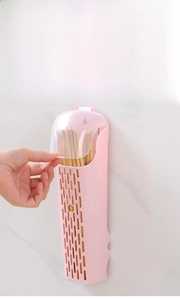 Dettaglio dell'apertura del coperchio trasparente del portabacchette a muro rosa