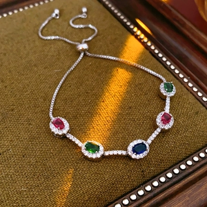 Makroaufnahme: verstellbares Silberarmband mit bunten ovalen Edelsteinen und Halo-Schliff