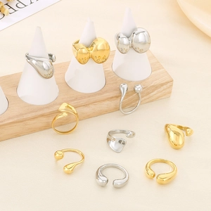 Polished 18K gold and silver rings with molten lava texture and fluid water-drop design