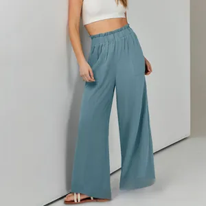 Dettaglio dei pantaloni a gamba larga in cotone e lino con vita alta elastica e tasconi