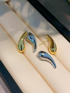 Detail showing gold and silver teardrop earrings with 925 silver needles and glossy finish