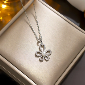 Elegant silver flower necklace with zircon petals and a center pearl on a jewelry box