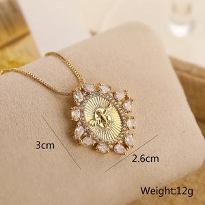 Macro view of gold angel pendant with zircon and dimensions 3cm x 2.6cm