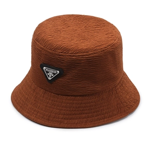 Caramel brown seersucker bucket hat with a triangular logo badge and adjustable fit