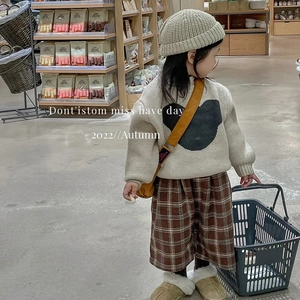Gros plan du bonnet en maille beige pour enfant avec un pull d'automne confortable