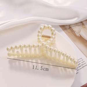 Detail shot of the 11.5cm cream pearl hair claw clip on soft white silk fabric