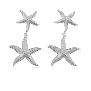 Detail view of silver starfish drop earrings with fine sunburst texture and layered design