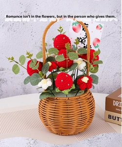 Detail of handcrafted crochet strawberry basket with knitted flowers in a rustic woven pot
