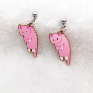 Detailed close-up of cute pink alloy cat earrings on white fluffy background