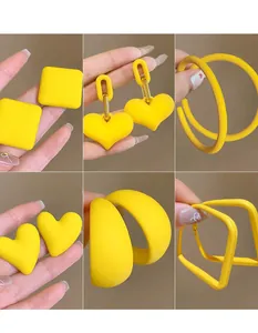 Close-up of six distinct yellow geometric acrylic earrings with matte finish